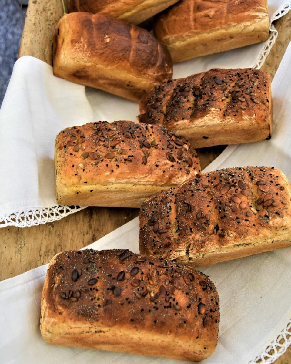 Bochenki chleba rozłożone na białym obrusie 